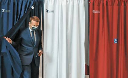 El presidente de Francia Emmanuel Macron abandona la casilla donde depositó su voto en el municipio parisino Le Touquet este domingo 27 de junio de 2021