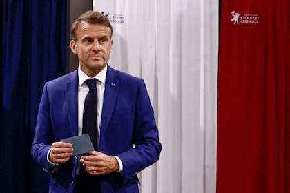El presidente de Francia, Emmanuel Macron, abandona la cabina electoral antes de emitir su voto en la primera ronda de las elecciones parlamentarias en una mesa electoral en Le Touquet, al norte de Francia, el 30 de junio de 2024.