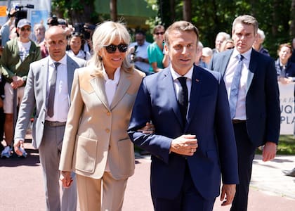 El presidente de Francia, Emmanuel Macron, y su esposa Brigitte Macron salen después de votar en la primera ronda de las elecciones parlamentarias francesas en Le Touquet, norte de Francia, el domingo 12 de junio de 2022.