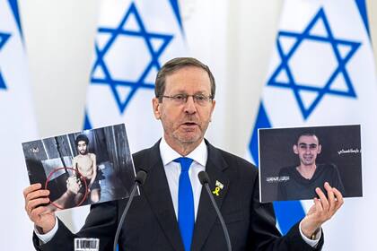 El presidente de Israel, Isaac Herzog, muestra fotos de ciudadanos israelíes encarcelados en la Franja de Gaza durante una declaración conjunta con el presidente de Lituania, Gitanas Nauseda, en el palacio presidencial de Vilna, Lituania, el lunes 4 de agosto de 2025