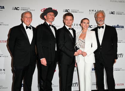 El presidente de la American Cinematheque, Mark Badagliacca, y otros miembros de la entidad posan junto la homenajeada, Scarlet Johansson, y al actor Jeremy Renner
