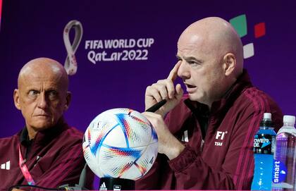 El presidente de la FIFA Gianni Infantino (derecha) charla con periodistas junto al director de la comisión de árbitros Pierluigi Collina (izquierda) en Doha, Qatar
