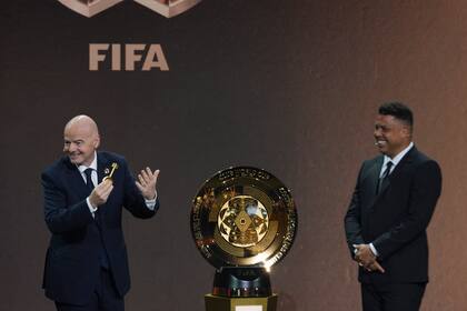 El presidente de la FIFA y el retirado futbolista Ronaldo presenta el trofeo del Mundial de Clubes, el jueves 5 de diciembre de 2024, en Miami. (AP Foto/Rebecca Blackwell)