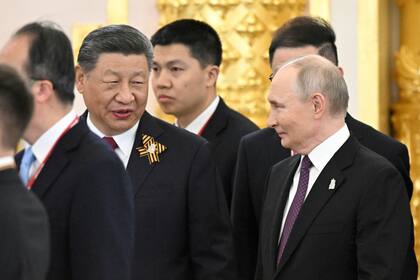 El presidente de Rusia, Vladímir Putin, a la derecha, y el presidente de China, Xi Jinping, hablan durante una cena ofrecida por el presidente de la Federación Rusa para los líderes de delegaciones extranjeras en el Gran Palacio del Kremlin, en Moscú, el jueves 8 de mayo de 2025