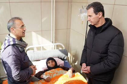 El presidente de Siria, Bashar al-Assad, visita a un herida por el terremoto que sacudió Turquía y Siria, en un hospital de la ciudad septentrional siria de Alepo, el 10 de febrero de 2023. 