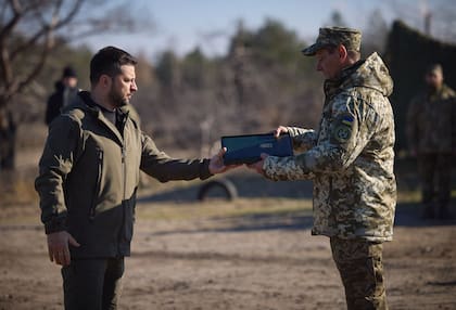 El presidente de Ucrania, Volodimir Zelensky, condecorando a un militar durante una visita a un centro de entrenamiento con motivo del Día de las "Fuerzas de Misiles y Artillería y de las Tropas de Ingenieros" en un lugar no revelado de Ucrania, en medio de la invasión rusa.