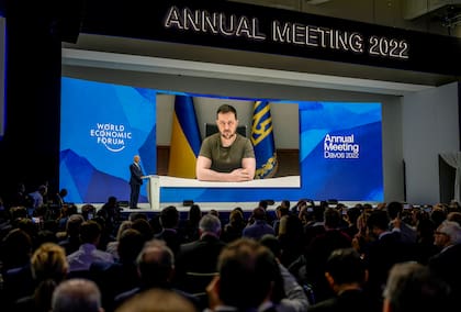 El presidente de Ucrania, Volodymyr Zelenskyy, aparece en una pantalla durante un discurso a distancia desde Kiev, durante el Foro Económico Mundial en Davos, Suiza, el lunes 23 de mayo de 2022.  (AP Foto/Markus Schreiber)