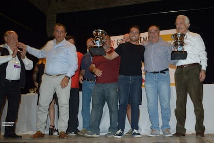 El presidente del ACA, Jorge Rosales (derecha), entrega la copa a los vencedores de la prueba