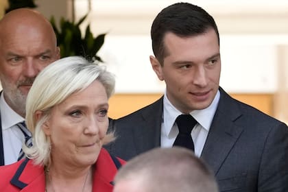 El presidente del partido de extrema derecha Reunión Nacional, Jordan Bardella, a la derecha, se retira junto a la líder ultraderechista Marine Le Pen tras una rueda de prensa, el lunes 24 de junio de 2024 en París. 