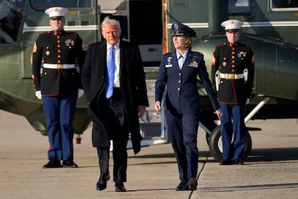 El presidente Donald Trump camina en dirección al Air Force One junto a la coronel Angela Ochoa en la Base Conjunta Andrews, Maryland, el 7 de febrero de 2025, para viajar a su mansión Mar-a-Lago en Palm Beach, Florida. (AP/Ben Curtis)