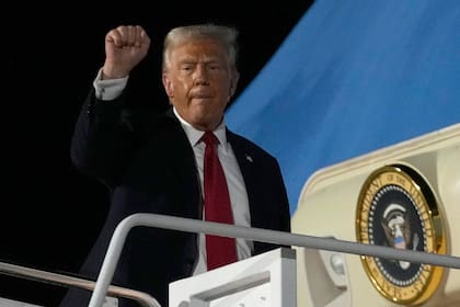El presidente Donald Trump cierra un puño mientras aborda el Air Force One en la Base de Reserva Conjunta de la Estación Aérea Naval (AP Foto/Ben Curtis)