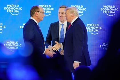 El presidente Donald Trump es recibido por el presidente del Foro, Borge Brende, y el copresidente del Foro, Larry Fink, en el podio antes de su discurso durante la Reunión Anual del Foro Económico Mundial en Davos, Suiza, el 21 de enero de 2026
