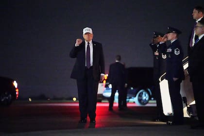 El presidente Donald Trump levanta el puño tras descender del Air Force One en el Aeropuerto Internacional de Palm Beach, en West Palm Beach, Florida.