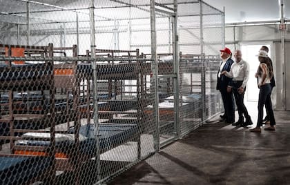 El presidente Donald Trump recorre un área recién construida para un campo de detención con la secretaria de Seguridad Nacional, Kristi Noem, en primer plano, en el Aeropuerto de Entrenamiento y Transición Dade-Collier en Ochopee, Florida, el 1 de julio de 2025