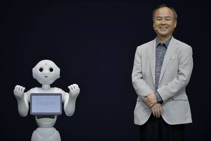 El presidente ejecutivo y presidente de SoftBank, Masayoshi Son, posa con el robot humanoide "Pepper" durante su presentación