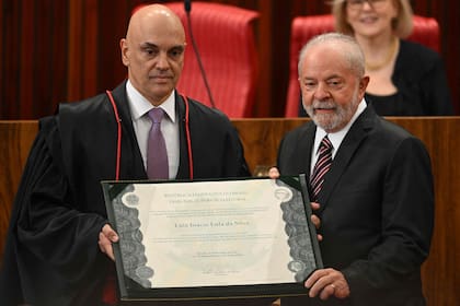 El presidente electo de Brasil, Luiz Inácio da Silva (d), recibe del presidente del Tribunal Superior Electoral (TSE), Alexandre de Moraes (i), el diploma de certificación durante una ceremonia en la sede del TSE en Brasilia, el 12 de diciembre de 2022.