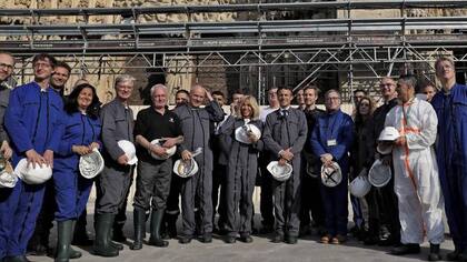 El presidente Emmanuel Macron y su esposa, Brigitte Macron, junto a trabajadores en la catedral de Notre Dame
