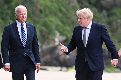 El presidente estadounidense Joe Biden camina junto al primer ministro británico Boris Johnson afuera del Hotel Carbis Bay, en Cornwall, Bretaña, previo a la cumbre del G7, el 10 de junio de 2021. (Toby Melville/Pool Photo via AP)