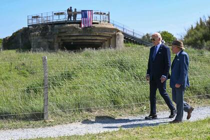 El presidente estadounidense Joe Biden y el superintendente del cementerio estadounidense de Colleville-sur-Mer, Scott Desjardins pasan junto a un búnker alemán de la época de la Segunda Guerra Mundial y una antigua instalación de armas costera en lo alto del acantilado "Pointe du Hoc" en Cricqueville-en-Bessin, noroeste de Francia, el 7 de junio de 2024