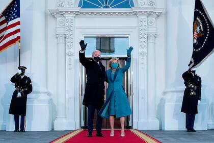 El presidente estadounidense Joe Biden y la primera dama Jill Biden saludan a su llegada a la Casa Blanca en Washington