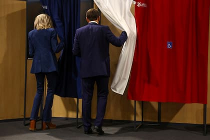 El presidente francés Emmanuel Macron y su esposa Brigitte Macron entran en una cabina de votación durante las elecciones europeas, el domingo 9 de junio de 2024 en Le Touquet-Paris-Plage, al norte de Francia. (Hannah McKay/Pool vía AP)