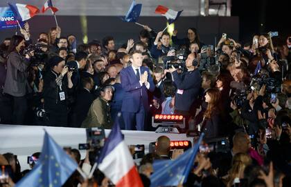 El presidente francés y candidato del partido La Republique en Marche (LREM) a la reelección, Emmanuel Macron, celebra tras su victoria en las elecciones presidenciales de Francia, en el Campo de Marte de París, el 24 de abril de 2022.