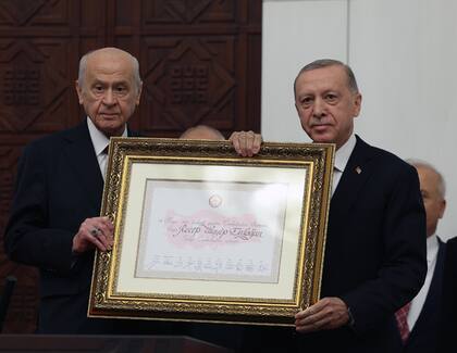 El presidente interino de la Gran Asamblea Nacional Devlet Bahceli (L) presenta un certificado de elección al presidente turco Recep Tayyip Erdogan durante la ceremonia de juramento 