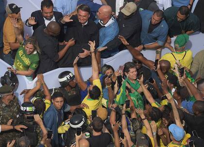 El presidente Jair Bolsonaro, junto a simpatizantes en Copacabana, en Río de Janeiro. (Photo by Carl DE SOUZA / AFP)