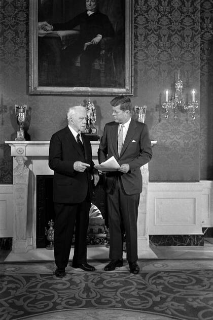 El presidente John F. Kennedy y el poeta Robert Frost conversan en la sala verde de la Casa Blanca bajo un retrato de John Quincy Adams