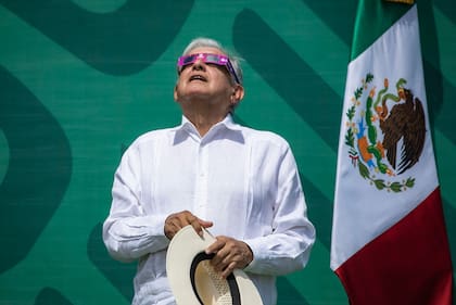 El presidente mexicano, Andrés Manuel López Obrador, usa gafas de sol especiales mientras observa un eclipse solar momentos antes de su totalidad, en Mazatlán, estado de Sinaloa, México, el 8 de abril de 2024