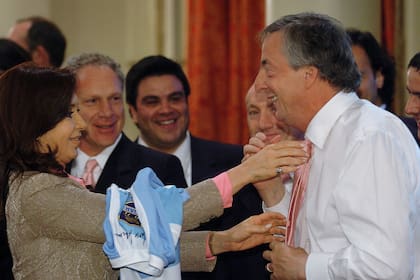 El presidente Néstor Kirchner espera a que su esposa Cristina Fernández le acomode la corbata que le obsequio uno de los jugadores de Los Pumas, la selección argentina de Rugby, el 23 octubre 2007