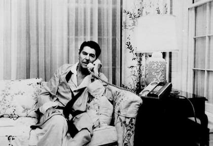 El presidente Ronald Reagan, en pijama y bata, hablando con el vicepresidente George H. W. Bush sobre Granada desde la Casa Blanca en 1983. (ARCHIVO-AP)