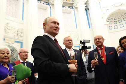 El presidente ruso, Vladímir Putin, comparte una copa con los galardonados tras una ceremonia de entrega de premios estatales en el Kremlin, en Moscú, el 20 de diciembre de 2022.