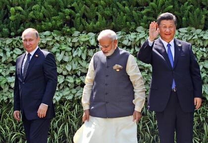 El presidente ruso Vladímir Putin, el primer ministro indio Narendra Modi, y el presidente chino Xi Jinping posan al inicio de la cumbre BRICS en Goa, India, el 16 de octubre de 2016. (AP Foto/ Anupam Nath, File)