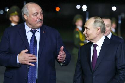 El presidente ruso, Vladimir Putin, escucha al presidente bielorruso, Alexander Lukashenko, mientras caminan el 23 de mayo de 2024 en Minsk. (Mikhail Metzel, Sputnik, foto compartida del Kremlin vía AP)