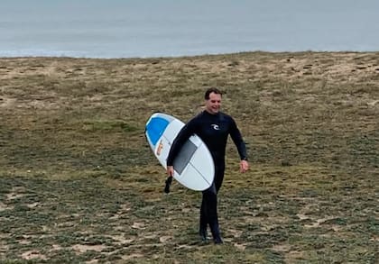 El presidente surfer. Lacalle Pou sale del agua después de una sesión de mediados de junio, en Maldonado (El País).