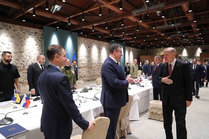 El presidente turco, Recep Tayyip Erdogan (derecha) saluda al jefe negociador ruso, Vladimir Medinsky (izquierda)