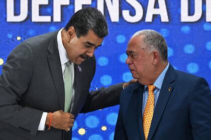 El presidente venezolano, Nicolás Maduro, conversa con el presidente del Consejo Nacional Electoral (CNE), Elvis Amoroso, durante una conferencia de prensa un día después del referéndum consultivo sobre la soberanía venezolana sobre la región del Esequibo controlada por la vecina Guyana, en la sede del CNE en Caracas el 4 de diciembre 2023.