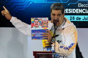 El presidente venezolano Nicolás Maduro sostiene un libro con su fotografía mientras habla en la Comisión Nacional Electoral, adonde llegó para formalizar su candidatura para postularse nuevamente a la presidencia en Caracas, Venezuela, el lunes 25 de marzo de 2024