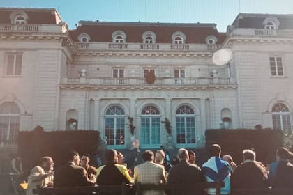 El presidente y sus hombres comparten un asado con sindicalistas, donde todo terminará mal; de fondo, la mansión de la estancia Abril
