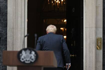 El primer ministro británico, Boris Johnson, regresa al número 10 de Downing Street en el centro de Londres después de hacer una declaración el 7 de julio de 2022. - Johnson renunció como líder del Partido Conservador, después de tres tumultuosos años en el cargo marcados por Brexit, Covid y crecientes escándalos
