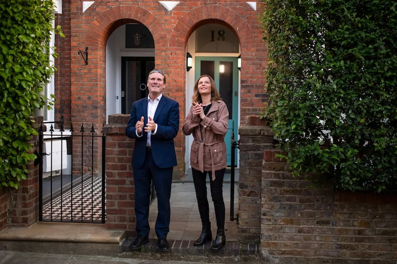 El primer ministro británico Keir Starmer junto a su esposa en la entrada de su casa.