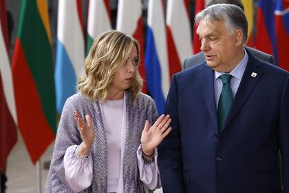 El primer ministro de Hungría, Viktor Orban, a la derecha, habla con la primera ministra de Italia, Giorgia Meloni, antes de una foto de grupo en una cumbre de la UE en Bruselas, el jueves 27 de junio de 2024.
