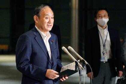 El primer ministro de Japón Yoshihide Suga habla con periodistas sobre levantar el estado de emergencia, el lunes 27 de septiembre de 2021, en la residencia oficial en Tokio. (Kyodo News via AP)