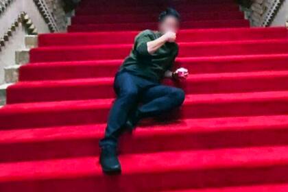 Shotaro Kishida acostado sobre las escaleras alfombradas de rojo de la Residencia Oficial del Primer Ministro
