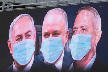 El primer ministro israelí Benjamin Netanyahu, junto a dos de sus ministros, en un cartel de propaganda para protegerse del coronavirus