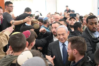 El primer ministro israelí, Benjamin Netanyahu saluda a la gente durante una visita a un asentamiento