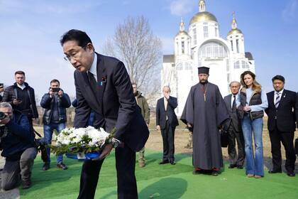 El primer ministro japonés, Fumio Kishida, deposita flores en una iglesia de Bucha, en Ucrania, el martes 21 de marzo de 2023.
