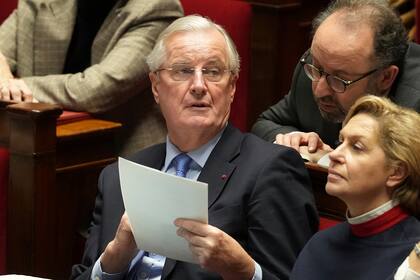 El primer ministro francés, Michel Barnier, sostiene un documento durante los discursos en la Asamblea Nacional antes del voto de confianza que derribó al premier y al gobierno por primera vez desde 1962, el 4 de diciembre de 2024 en París. (AP/Michel Euler)