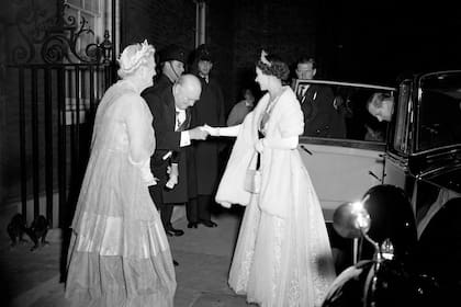 El primer ministro Sir Winston Churchill se inclina ante la reina Isabel II mientras les da la bienvenida a ella y al duque de Edimburgo en el número 10 de Downing Street para cenar